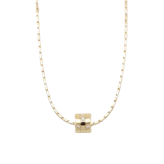 Gold honeycomb necklace with a small cube pendant on a white background