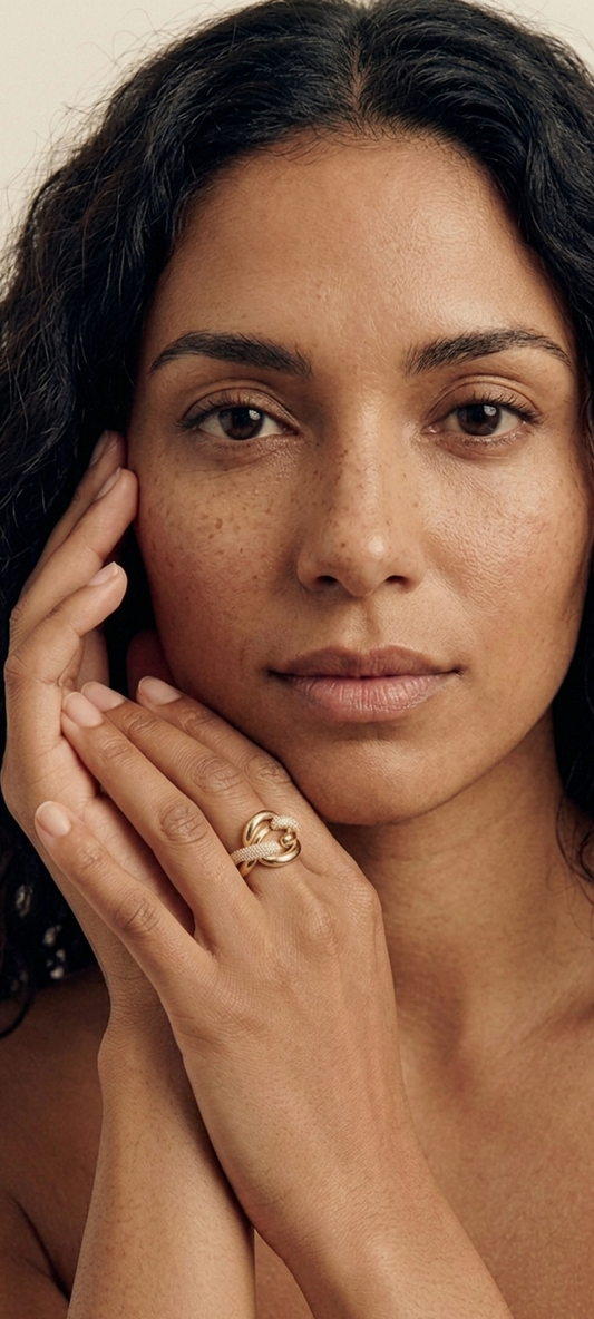 Woman with a gold ring on her finger against a neutral background